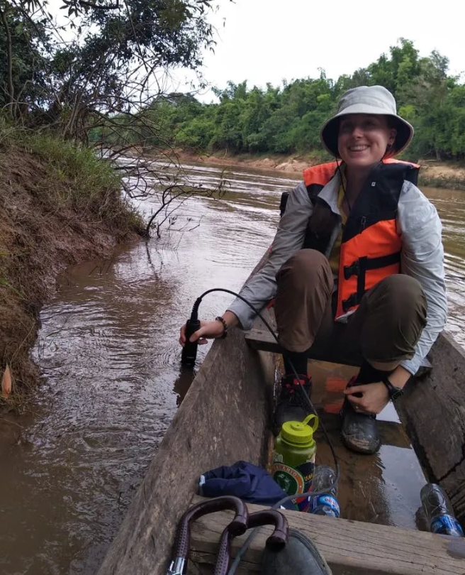 A girl in a boat smiles at the camera