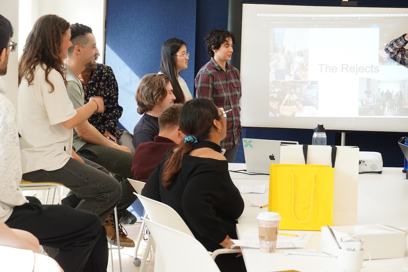 Students listen to a presentation being given by a person out of the camera
